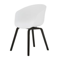 An angled perspective of the monochromatic Macey dining chair, highlighting the striking contrast between the bright white curved shell and the steam-bent black ply legs.