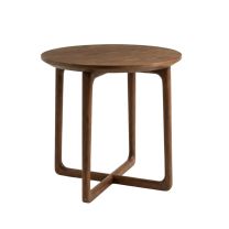 Angled view of the Astrid Round Side Table in walnut, showcasing the circular top and the sculptural cross-base legs.