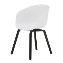 An angled perspective of the monochromatic Macey dining chair, highlighting the striking contrast between the bright white curved shell and the steam-bent black ply legs.