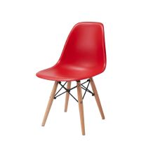 An angled front perspective of the vibrant red Replica Charles Eames Kids Chair, highlighting the highly practical, easy-to-clean plastic shell and the sturdy beech timber legs.