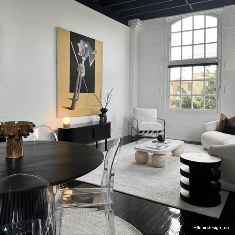 Modern Sydney apartment living and dining area with transparent chairs, a round dining table, and contemporary furniture.
