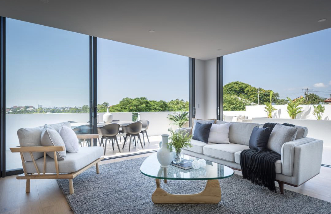 Corner of a modern Brisbane living room featuring the iconic Replica Isamu Noguchi Coffee Table and expansive balcony views.	