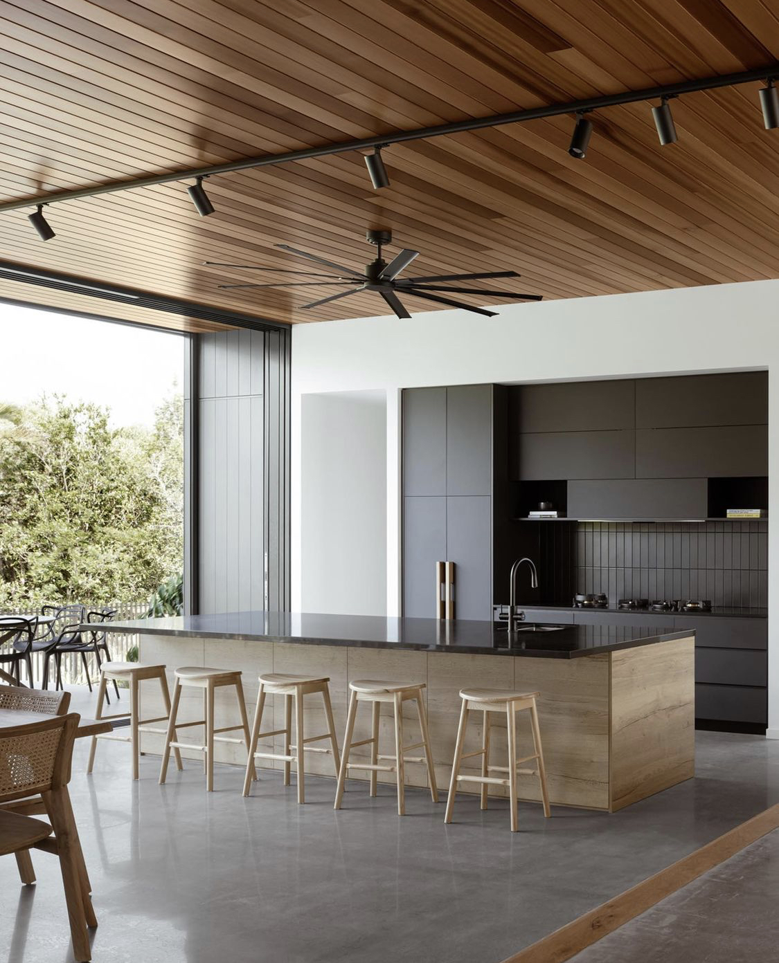 Scandinavian Replica Bar Stools in Ash wood at a modern Brisbane kitchen counter with ceiling fans.	