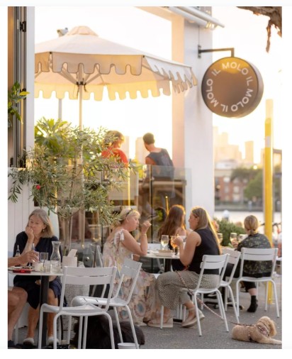 Replica Fermob Chairs: Durable Cafe Furniture for the Sydney Climate. Outdoor cafe setting at Bondi Beach featuring white Replica Fermob Chairs and tables.