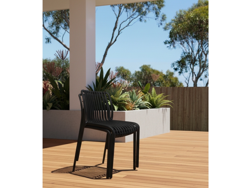 Bordeaux Stacking Polypropylene Outdoor Dining Chair in black, placed on an Australian timber deck.