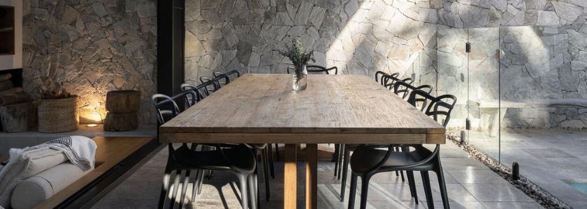 Black Replica Masters chairs in a modern Brisbane indoor-outdoor area near a pool. Durable outdoor furniture for the Queensland climate.