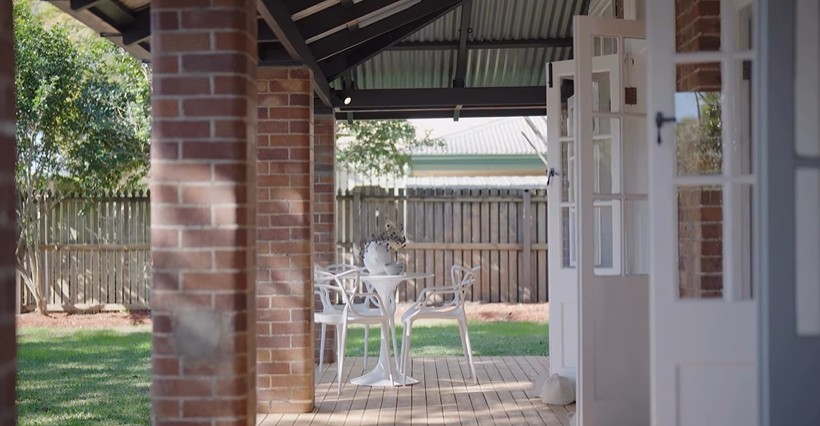 Outdoor verandah area featuring a Replica Tulip Chair and two White Replica Masters Chairs. Perfect for Queensland outdoor living.	