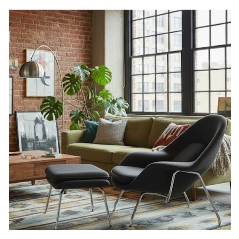 Industrial-chic apartment interior in Melbourne featuring dark tones and a stylish replica lounge chair.