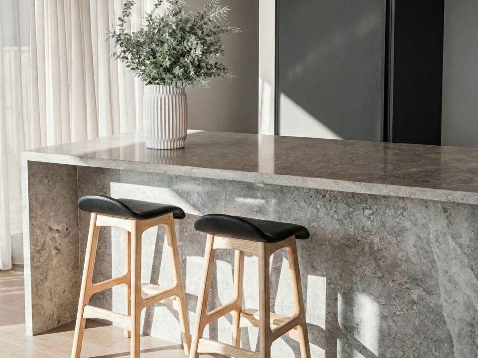 Shop the organic Replica Erik Buch Stool. Replica Erik Buch Bar Stool in white leather and timber, showing the organic curved seat design at a kitchen bench.