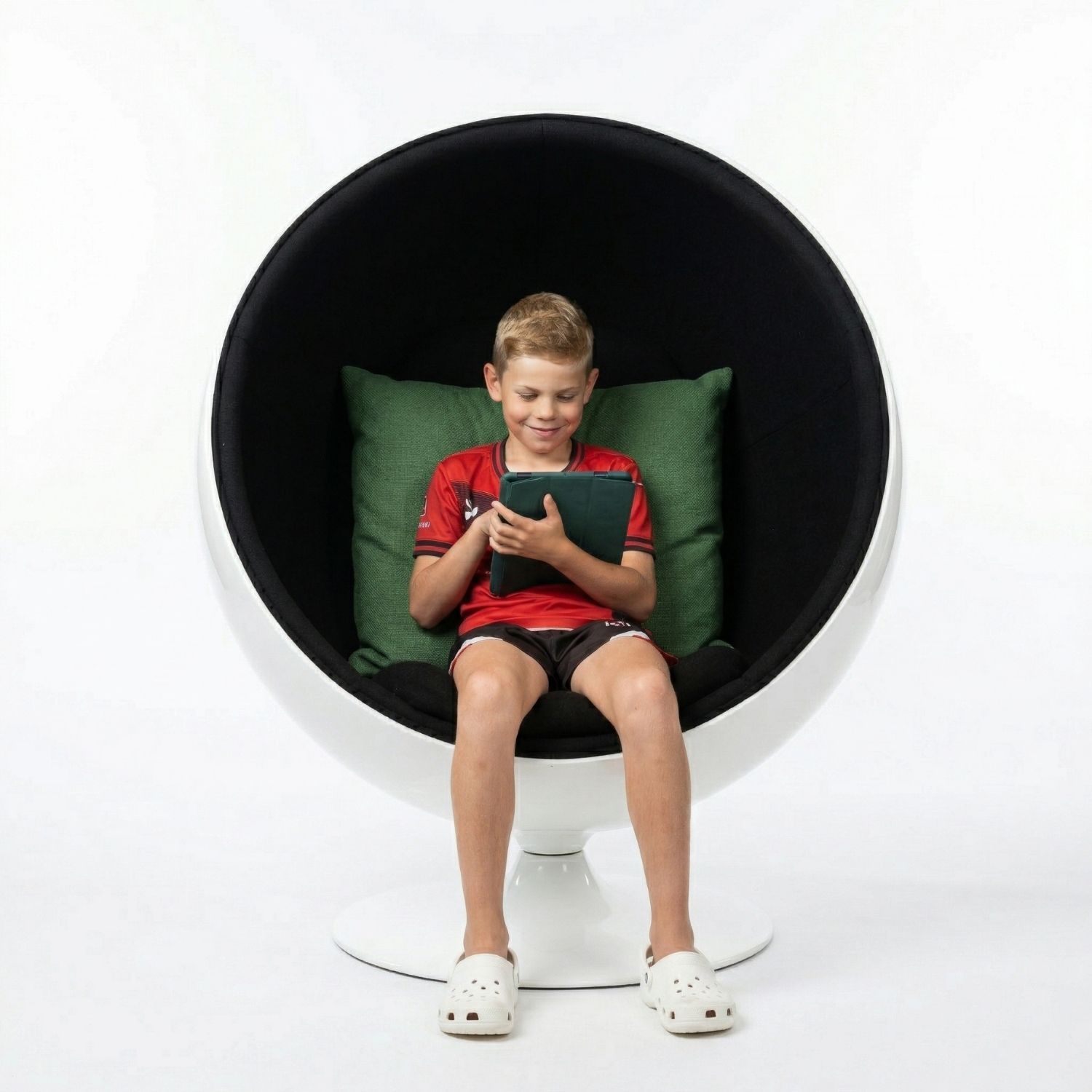 A Grade 4 boy sitting comfortably inside a black Replica Premium Ball Chair, using the enclosed space for calming sensory regulation.