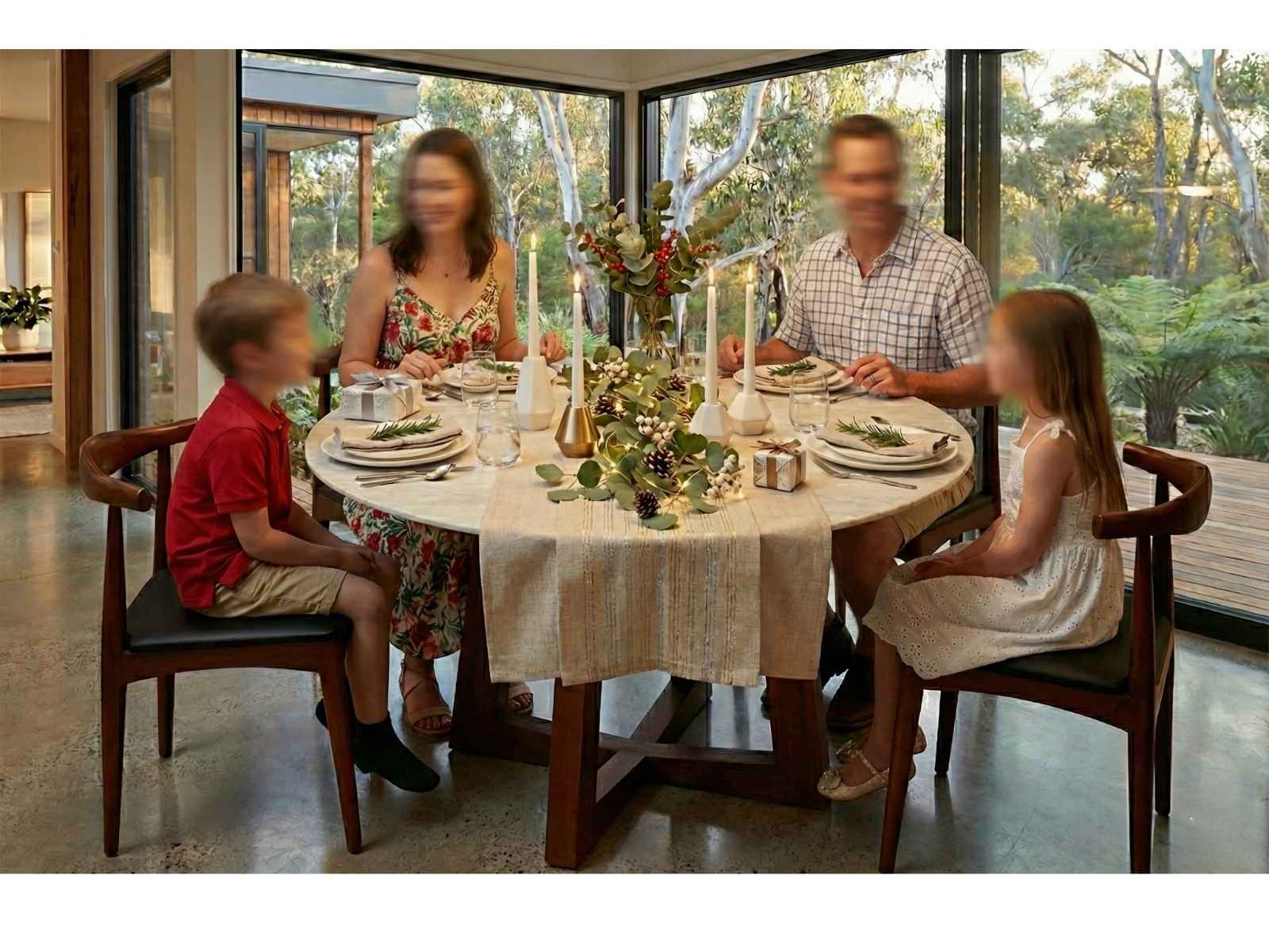 Shop In-Stock: Zodiac Round Marble Dining Table. Family enjoying Christmas lunch at a Zodiac Round Marble Dining Table paired with Replica Elbow Chairs, featuring a modern Australian bush view.